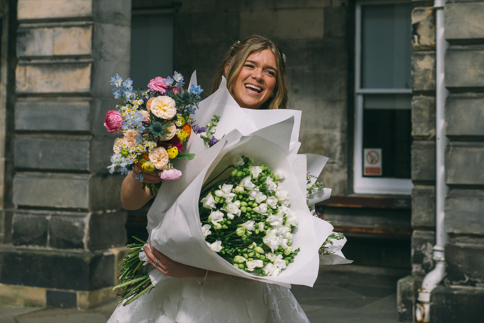 Nandi holding two bouquets and smiling